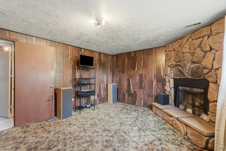 Focal stone-clad fireplace with hearth and metal grate