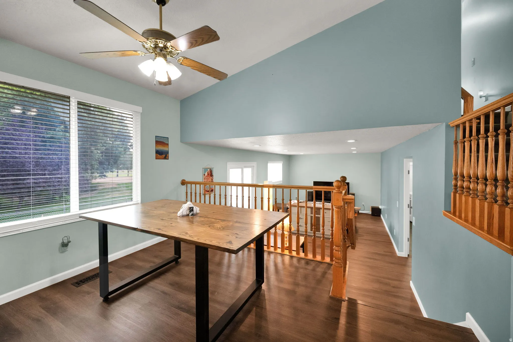 Vaulted ceilings over a dining area with wood-finish flooring