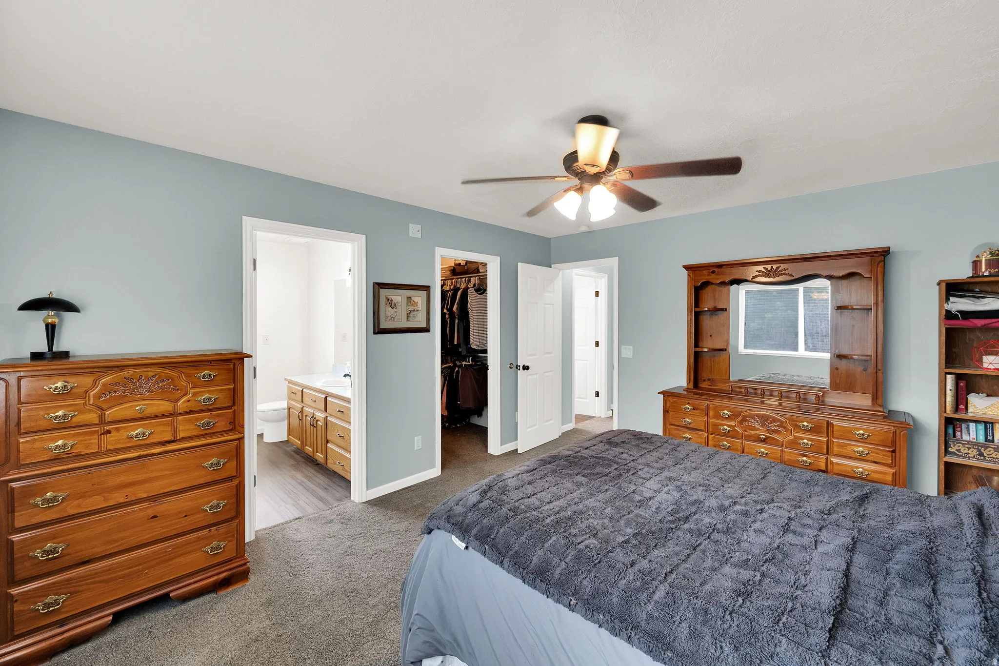 Bedroom featuring light blue walls, gray carpet, and a ceiling fan with integrated lighting