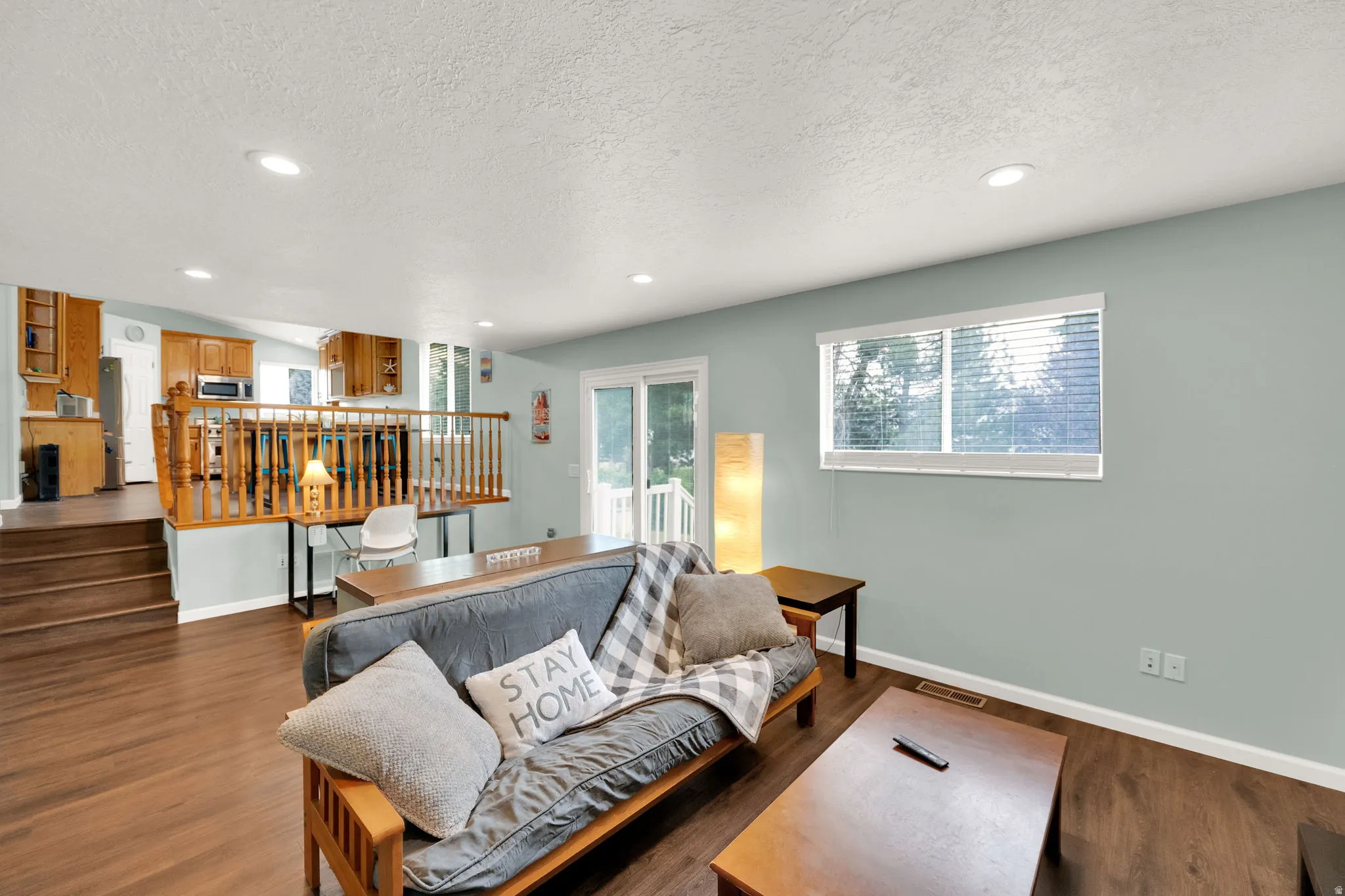 Open-concept living area featuring wood-finish flooring, recessed lighting, and a sliding glass door to the exterior