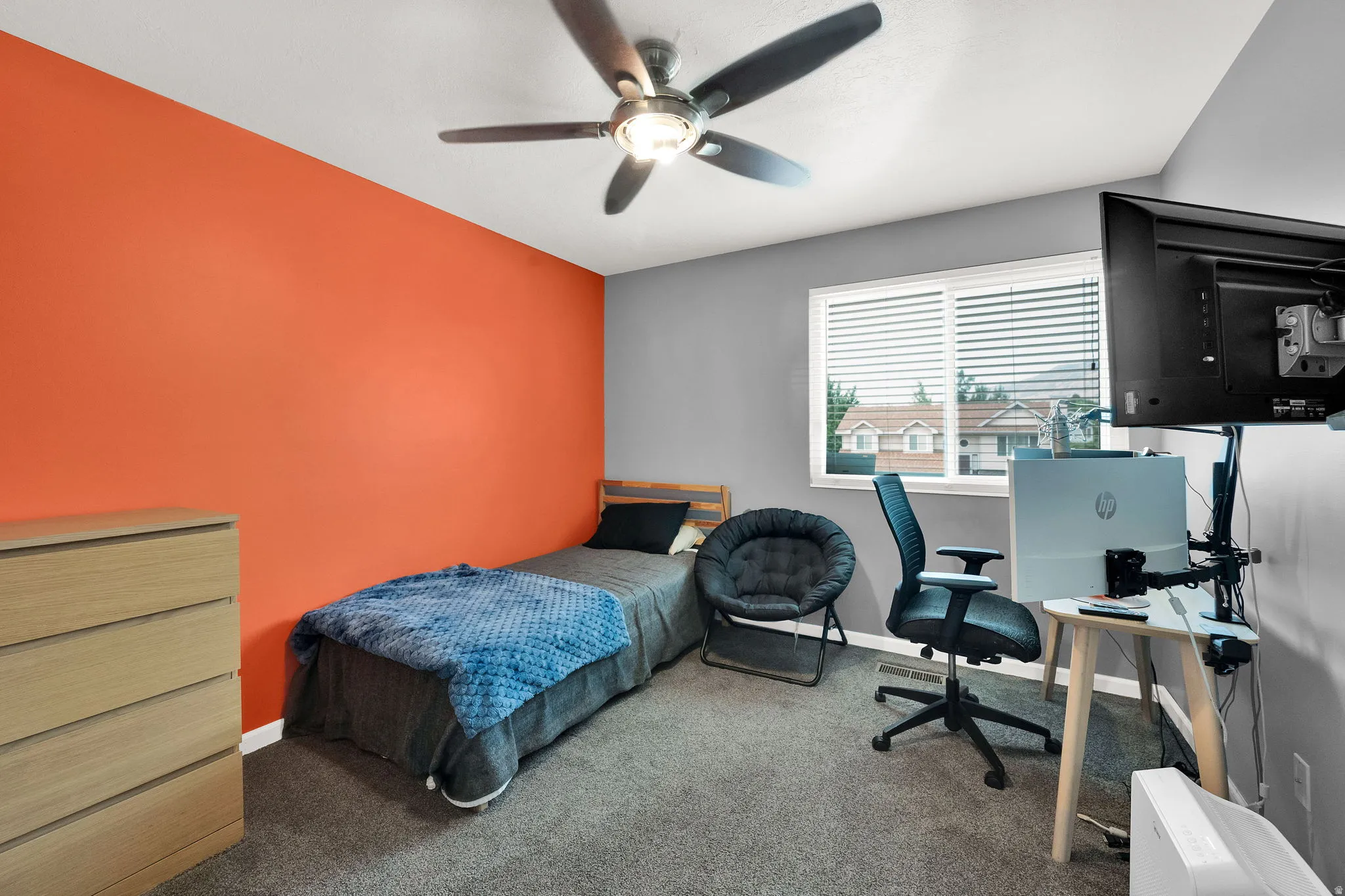 Bright interior space featuring a ceiling fan with integrated lighting, a window with blinds, and carpet flooring
