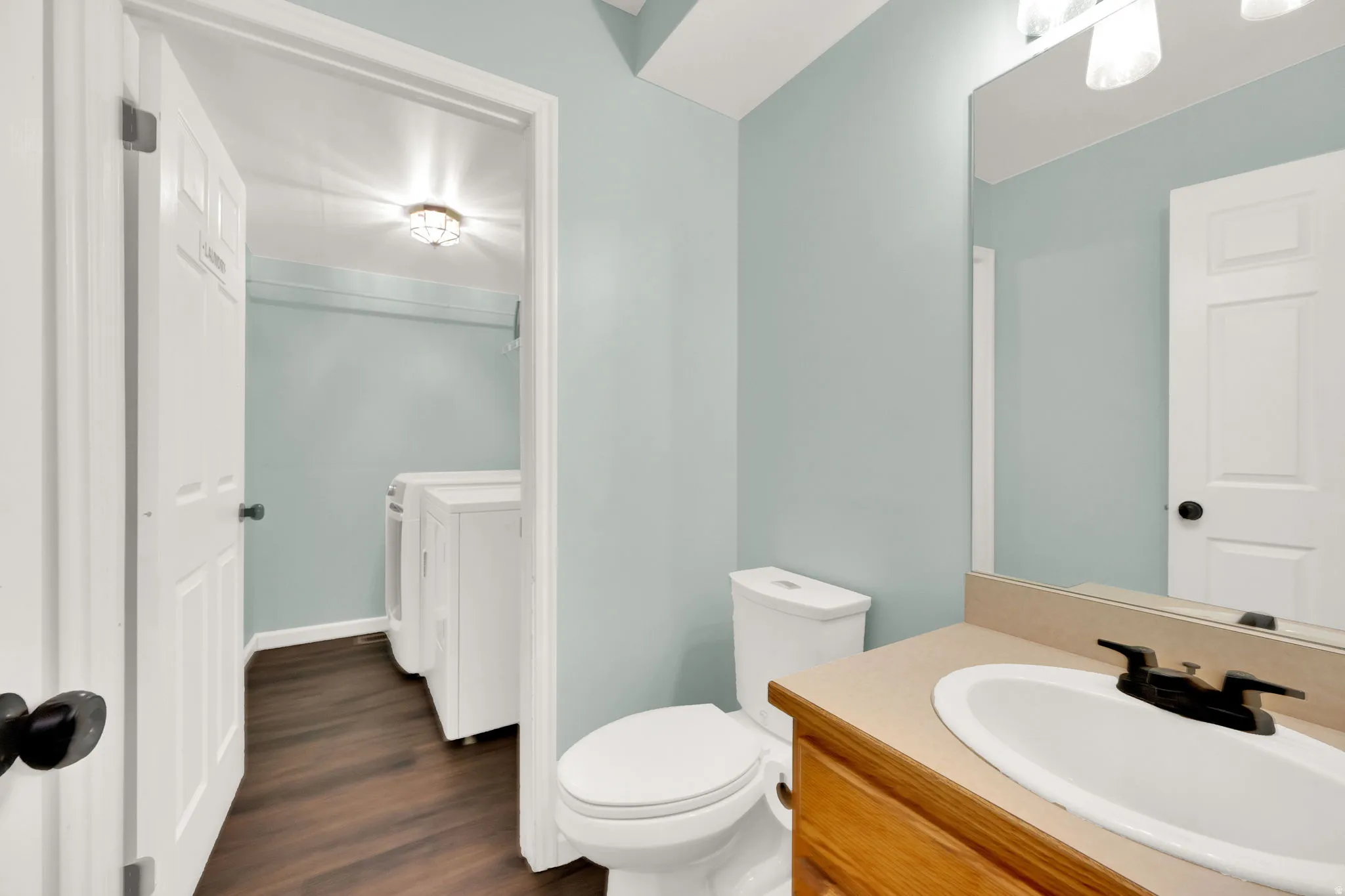Bathroom vanity with a built-in sink, dark bronze faucet, and a large wall-mounted mirror