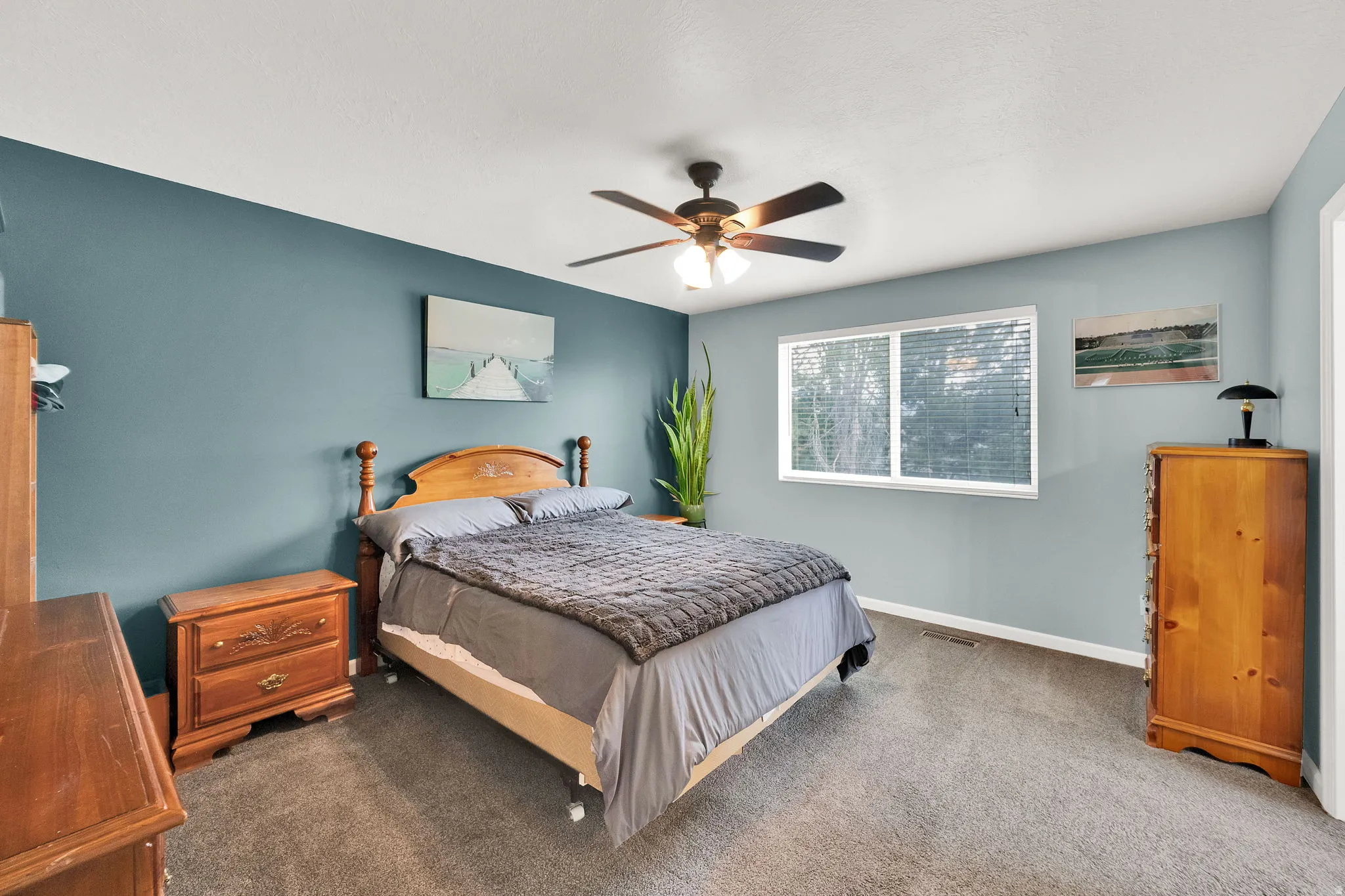 Spacious bedroom featuring light blue walls, a white ceiling, and grey carpeting