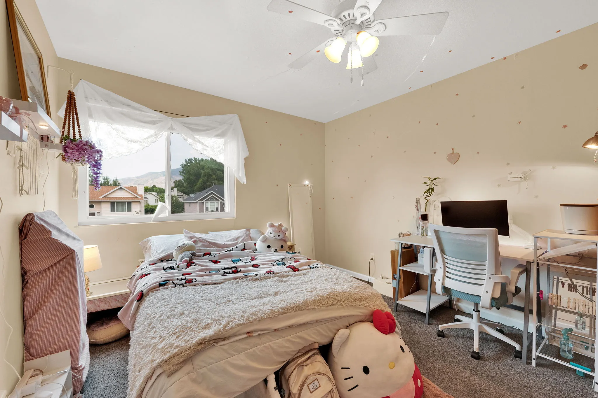 Carpeted room featuring a ceiling fan, a window with a mountain backdrop, and neutral-toned walls