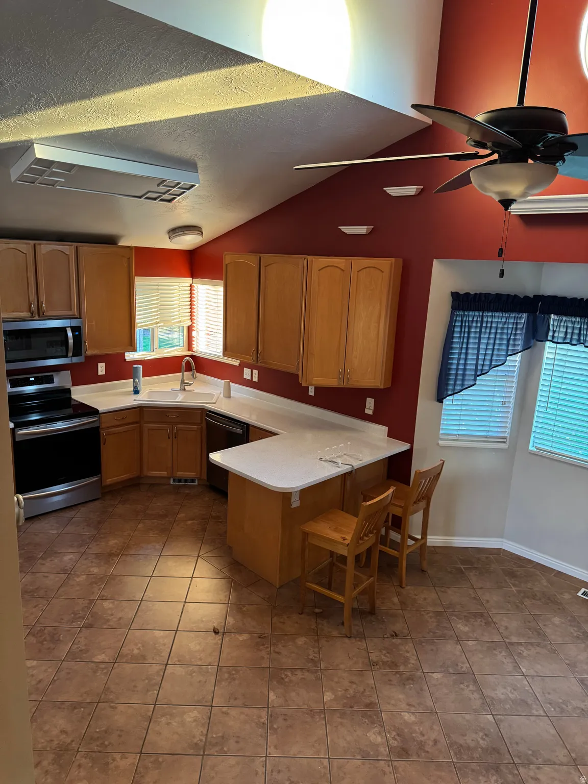 Kitchen featuring light wood cabinetry, white countertops, and stainless steel appliances