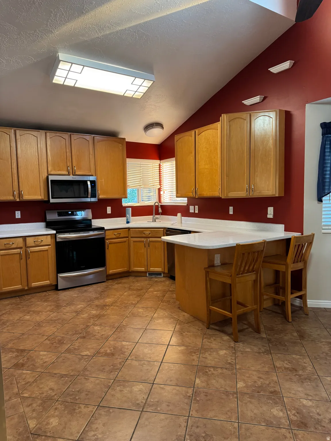 Kitchen featuring a vaulted ceiling and tile flooring