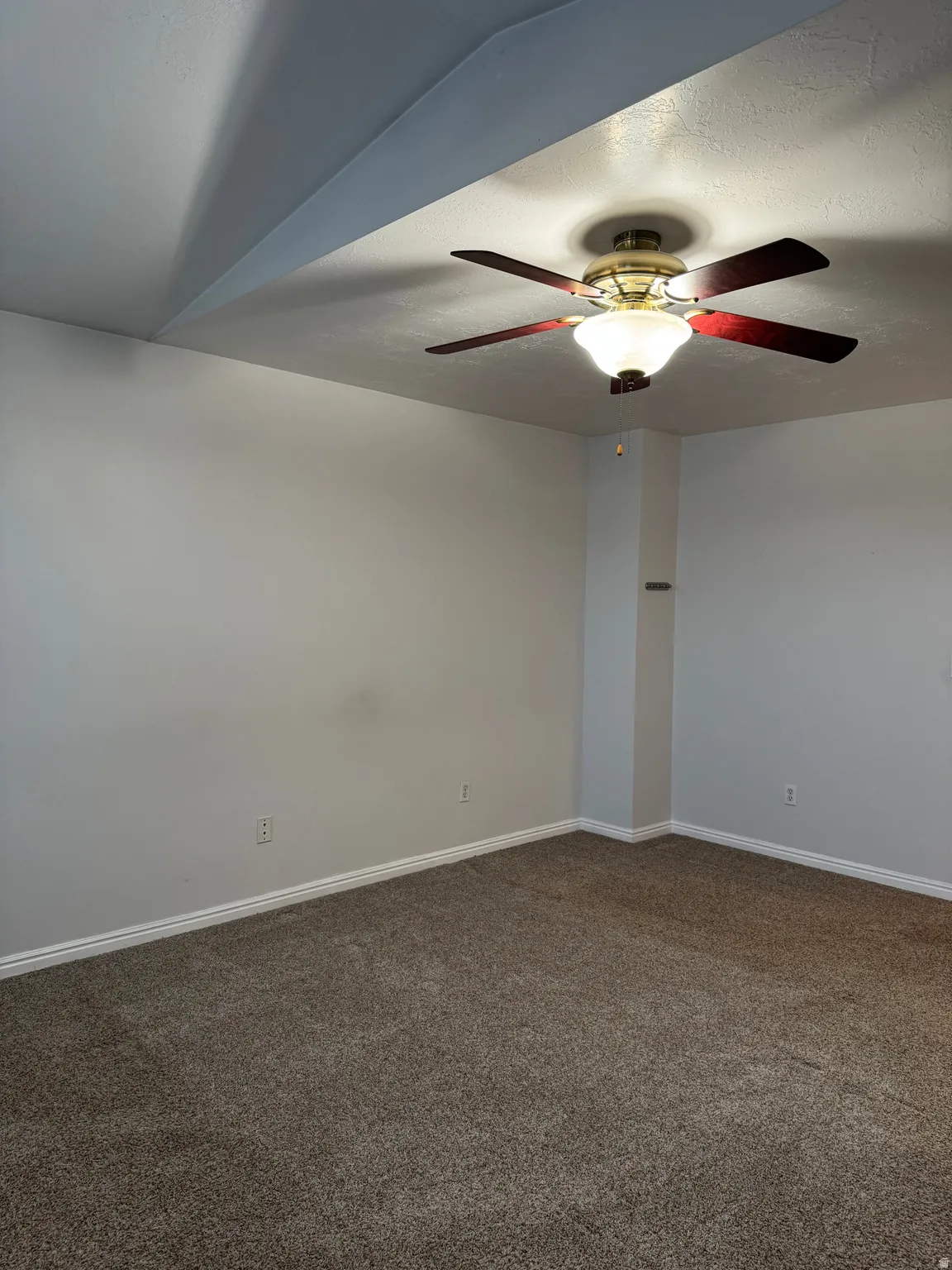 Recessed ceiling fan with integrated lighting, textured carpeting, and white baseboards