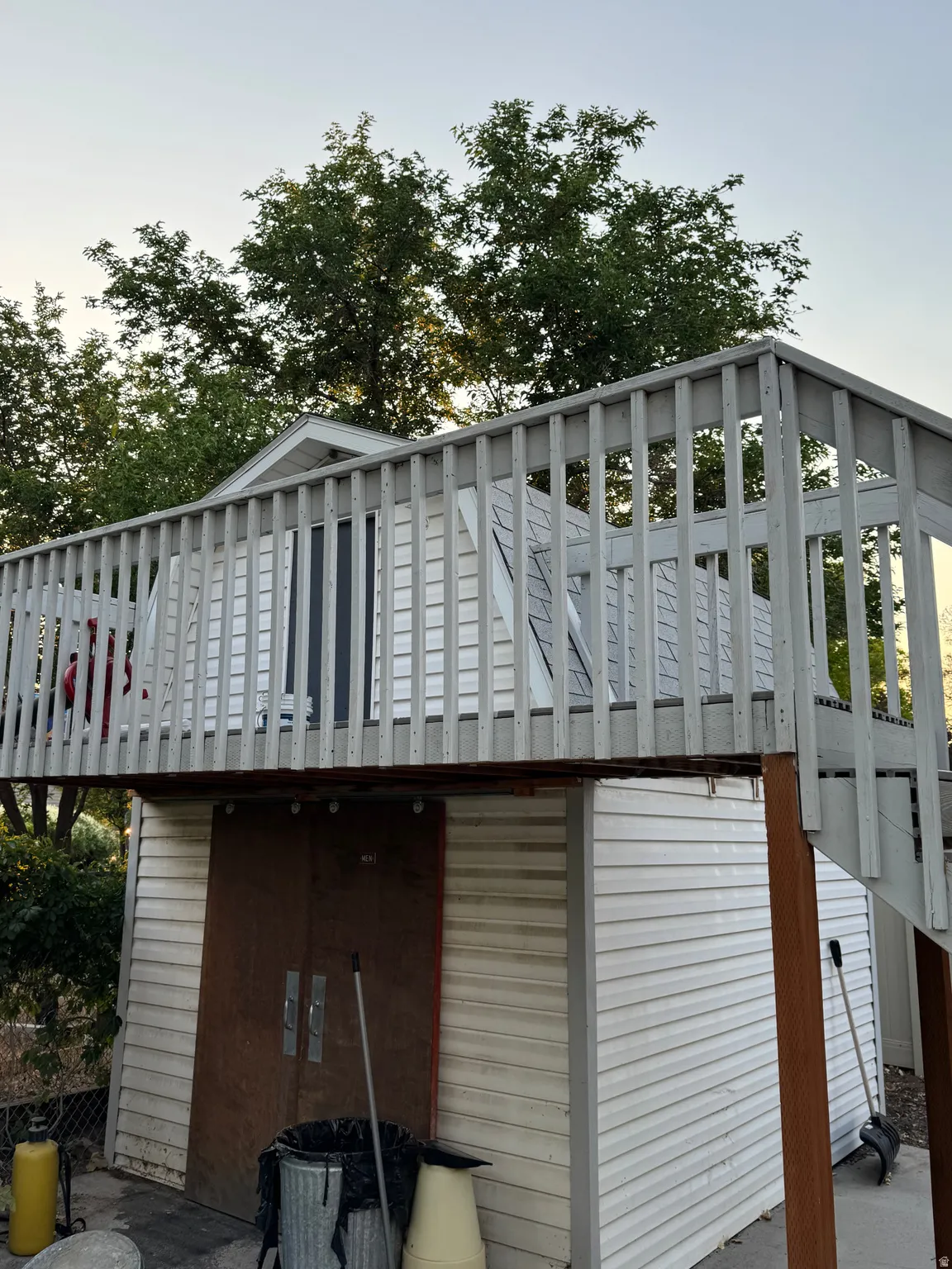 Elevated deck with wood railing on the shed.