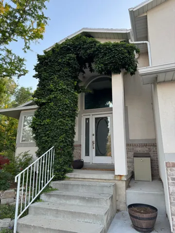 Entryway featuring a double door with decorative glass, a transom window, and a full-height column