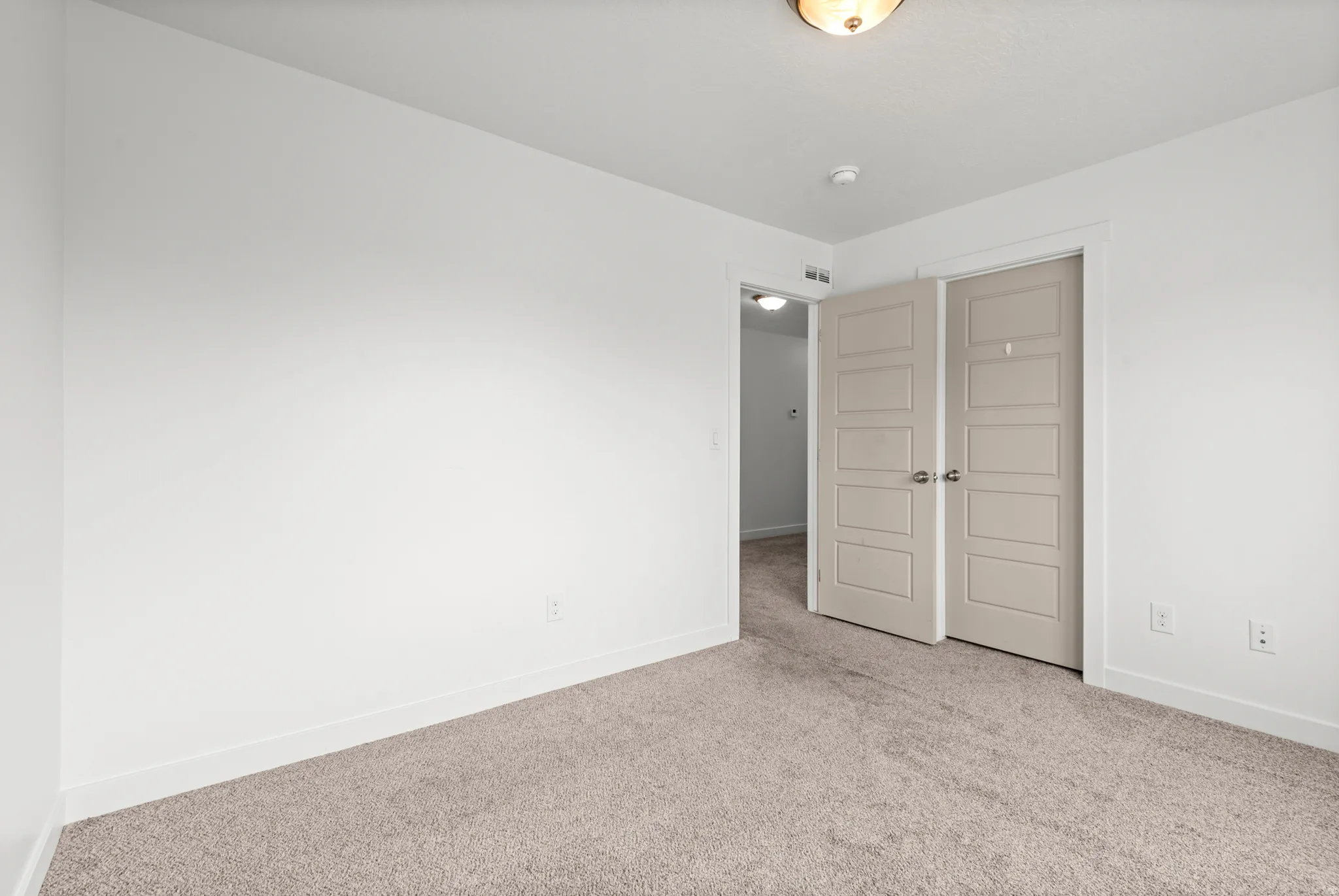 Neutral tone-on-tone carpeting complements white walls and trim