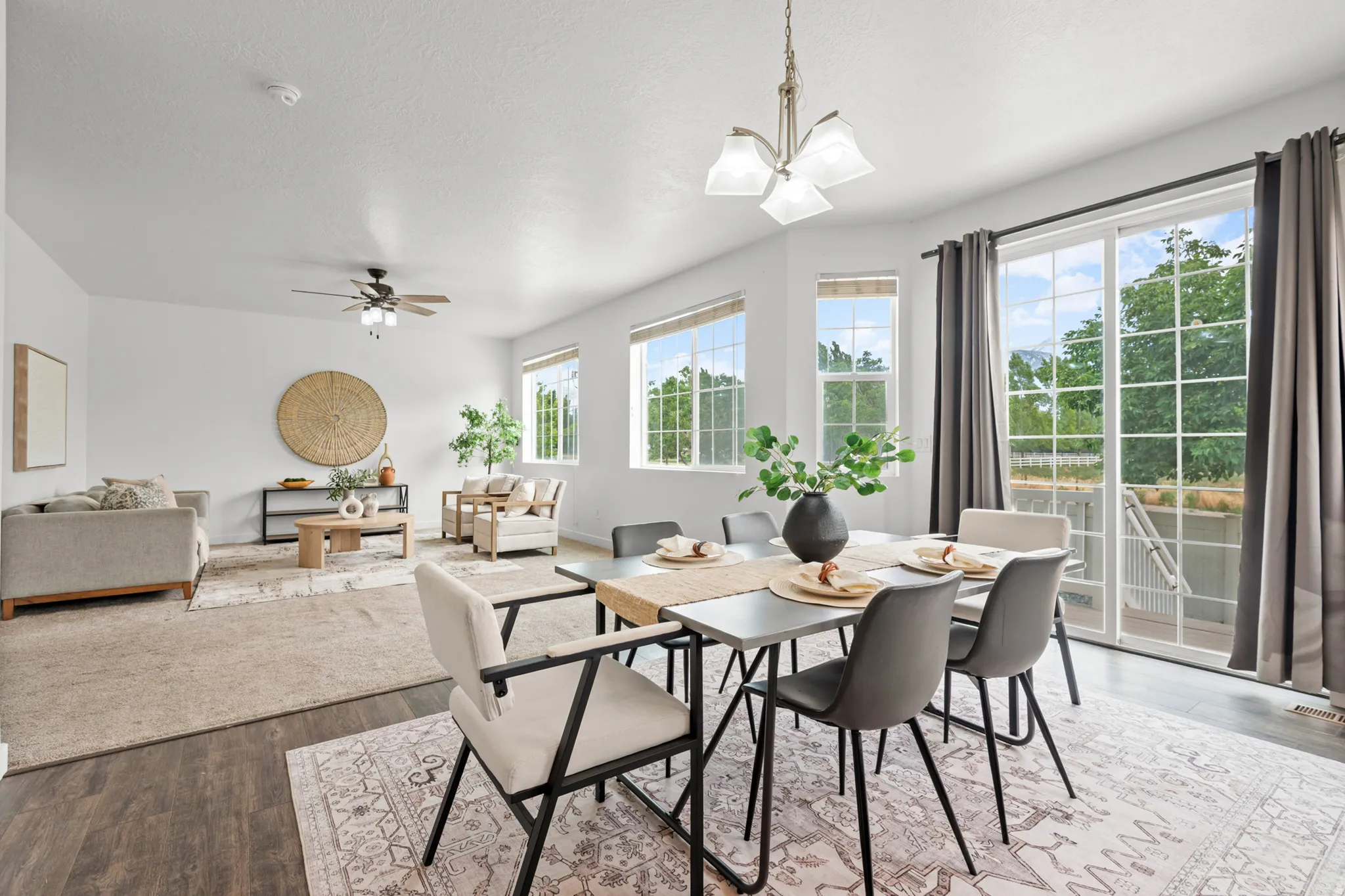 Open-concept living and dining areas featuring dark wood-finish flooring, abundant natural light, and a sliding glass door leading to the exterior