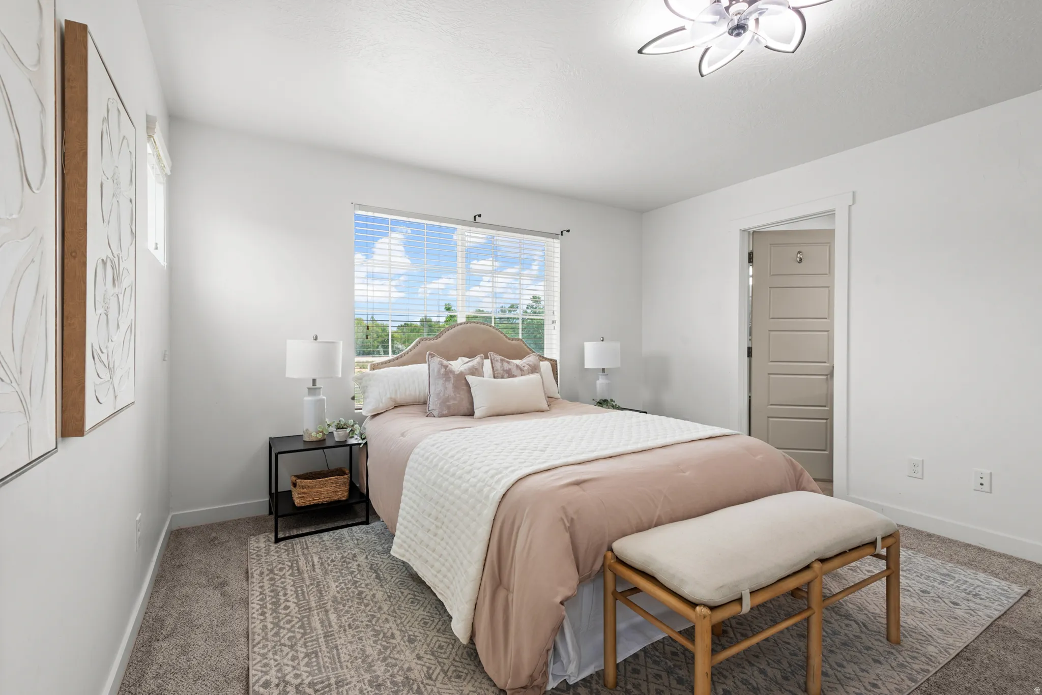 Bedroom with a large window, plush carpet flooring, a ceiling-mounted light fixture, and a paneled interior door