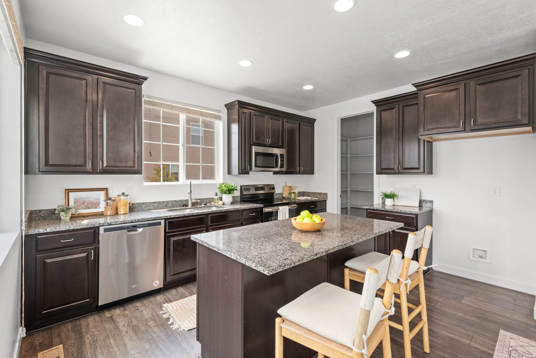 Kitchen featuring dark wood-finish cabinetry and granite countertops