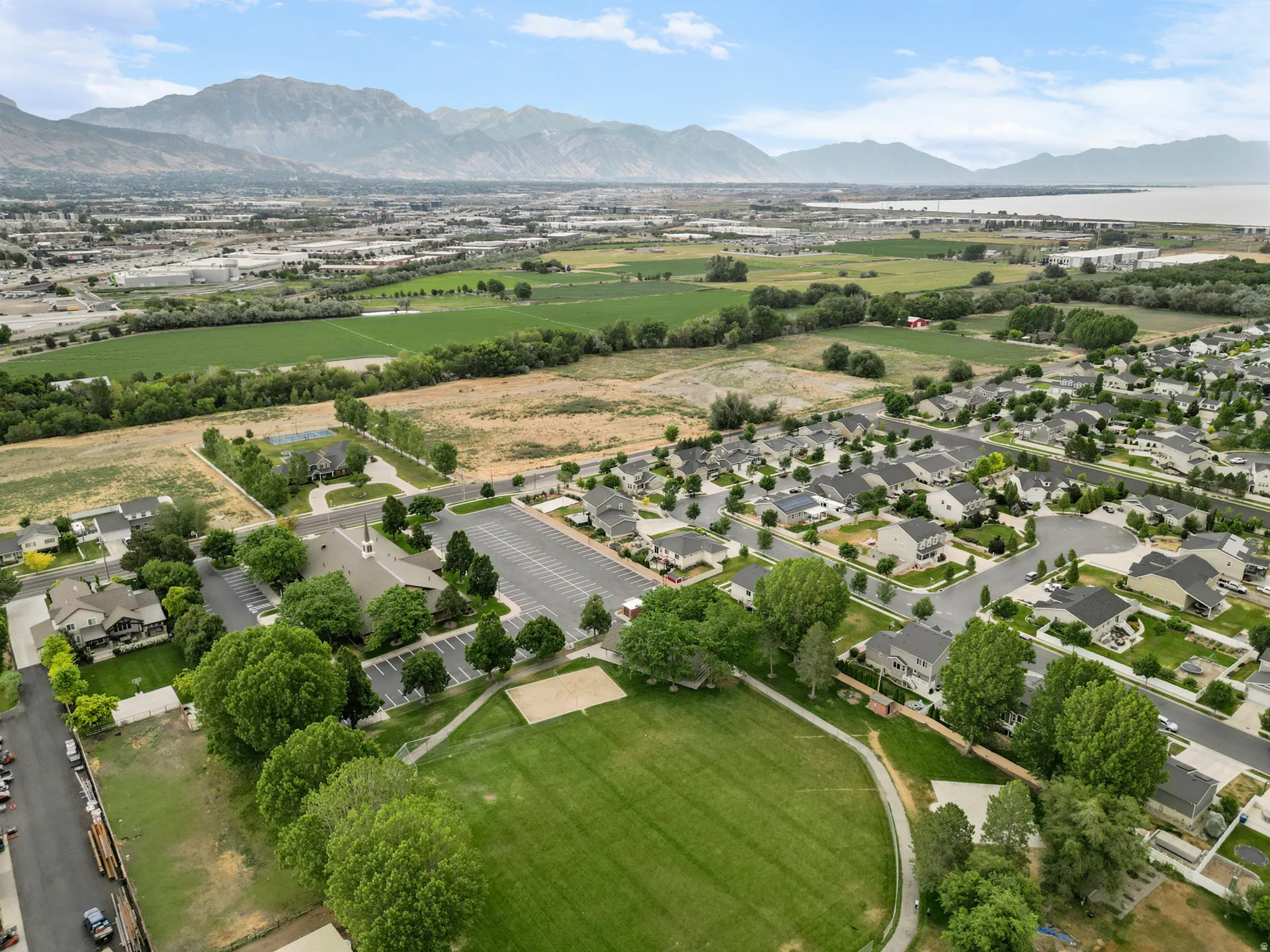 Aerial perspective showcasing a residential neighborhood with mountain and water backdrops
