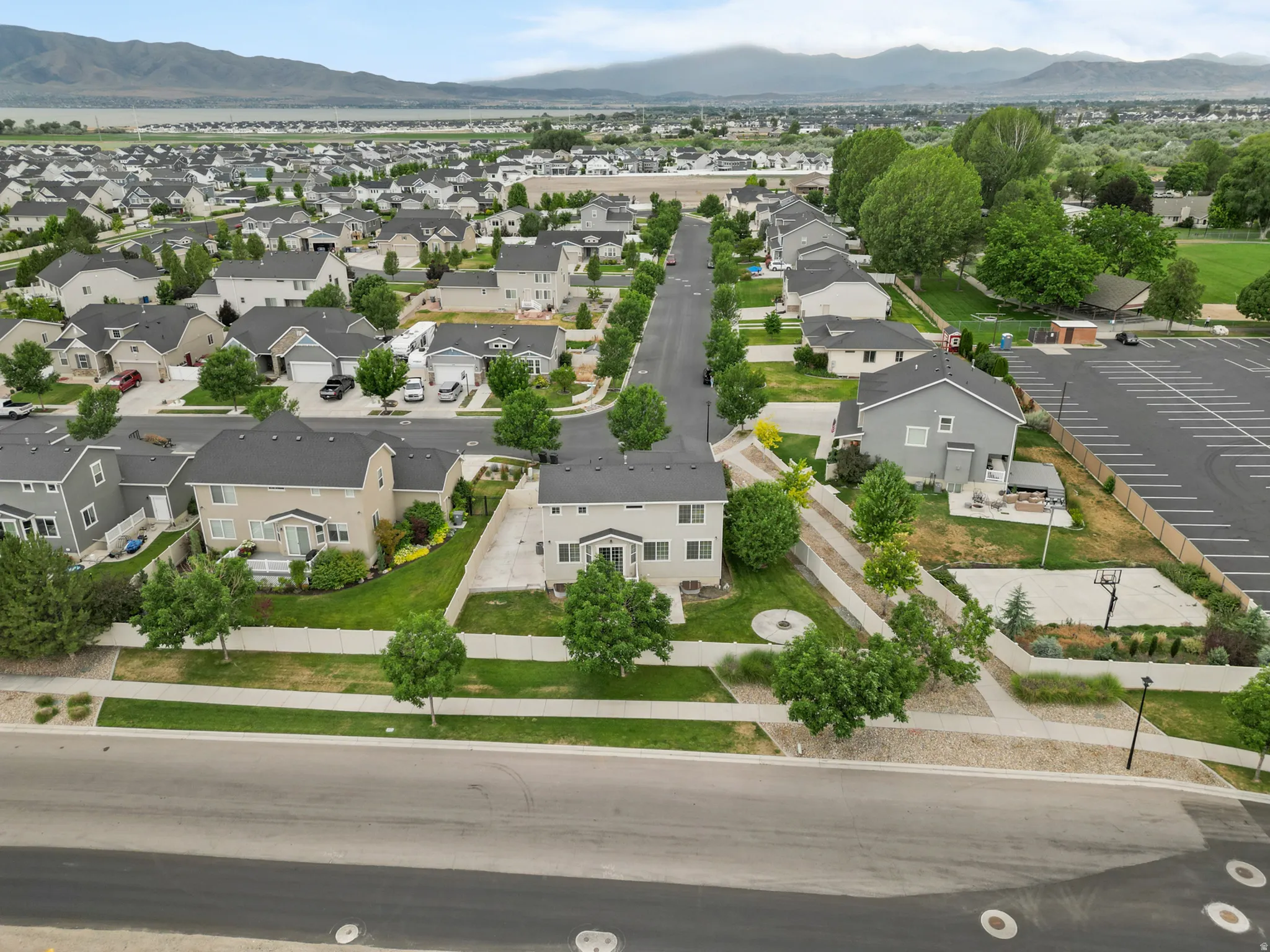 Aerial perspective of a developed residential area with distant mountains and a body of water