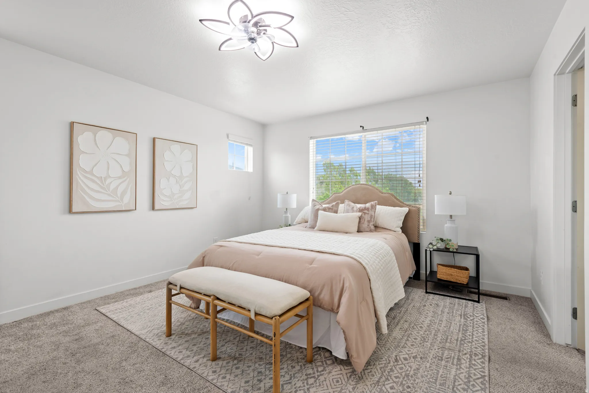 Carpeted room featuring a large window with blinds, a smaller upper window, and a modern ceiling light fixture