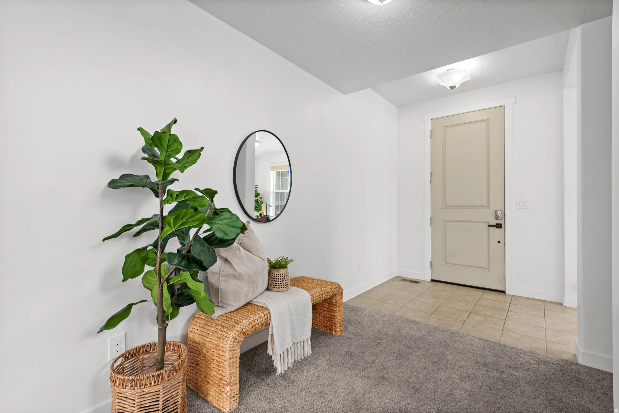 Entryway featuring a panel door with dark hardware, tile flooring, and overhead lighting
