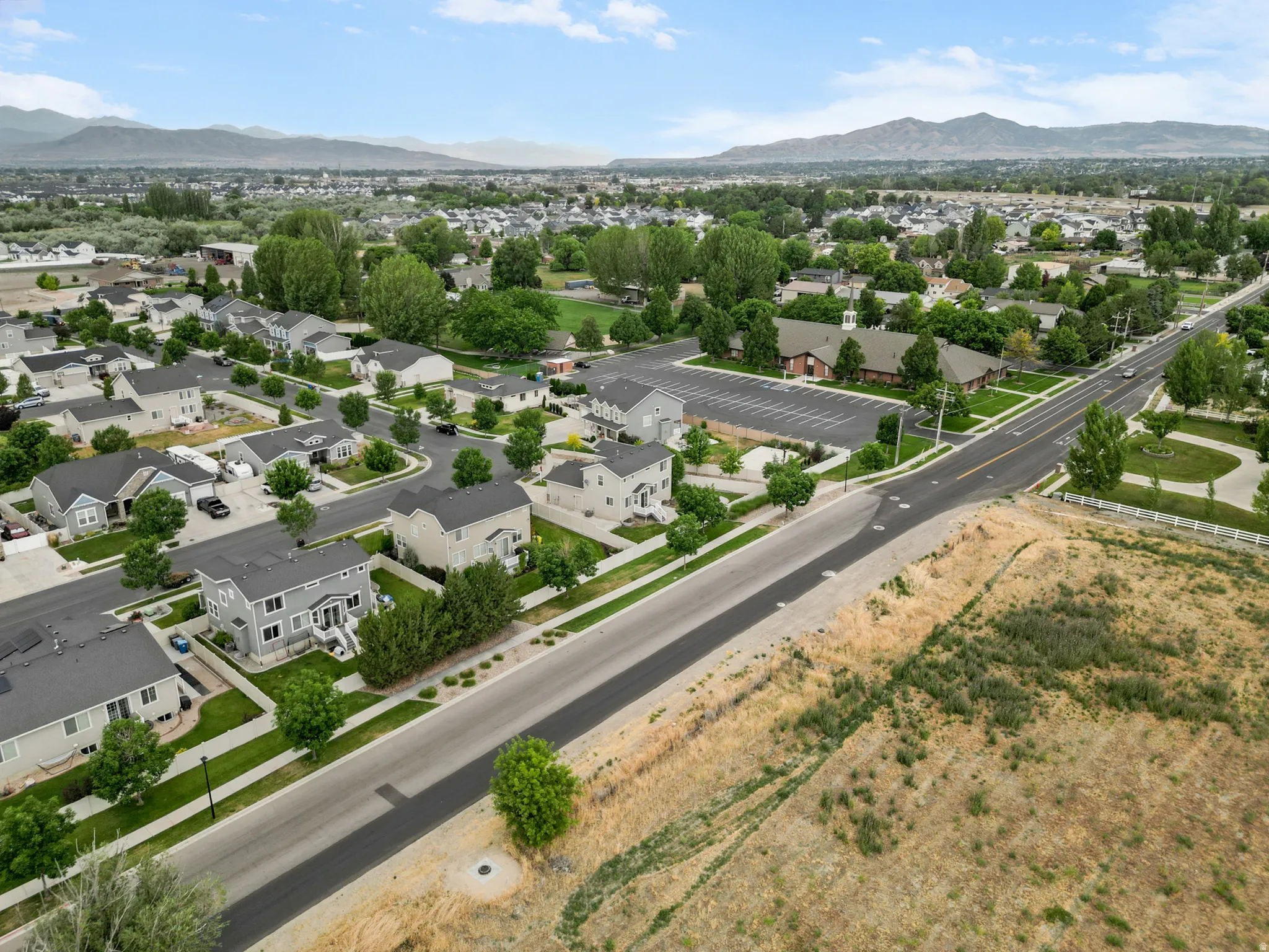 Aerial perspective showcasing a residential neighborhood with mountain backdrops
