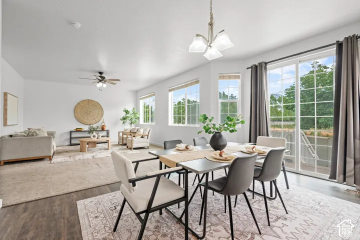 Open-concept living and dining areas featuring dark wood-finish flooring, abundant natural light, and a sliding glass door leading to the exterior