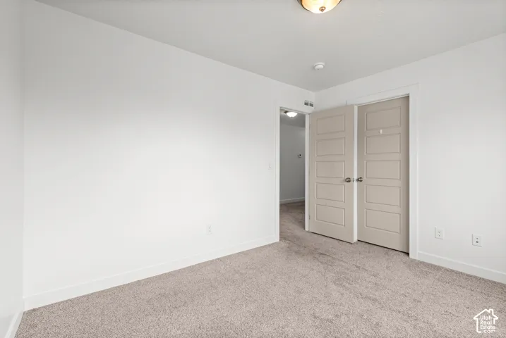 Neutral tone-on-tone carpeting complements white walls and trim