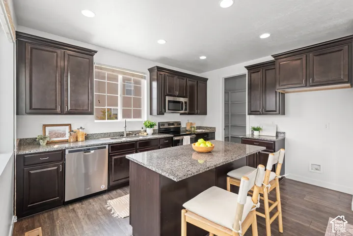 Kitchen featuring dark wood-finish cabinetry and granite countertops