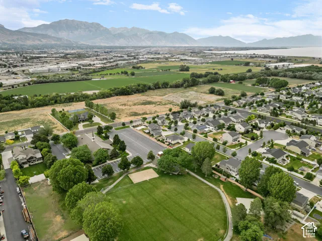 Aerial perspective showcasing a residential neighborhood with mountain and water backdrops