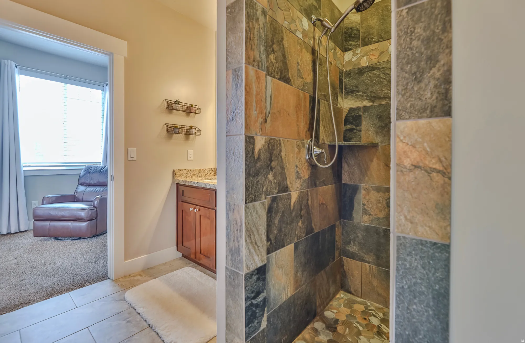 Stone-tiled shower with a pebble-stone floor and built-in niche