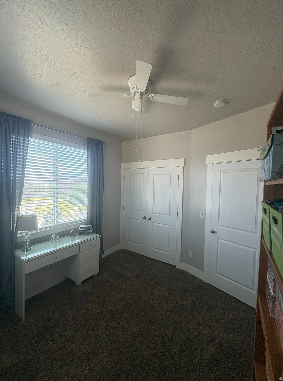 Room featuring a window with blinds, a ceiling fan, and carpeted flooring