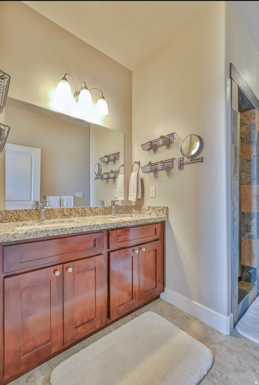 Master Bathroom. Dual vanity with wood cabinetry, granite countertop, and integrated sinks