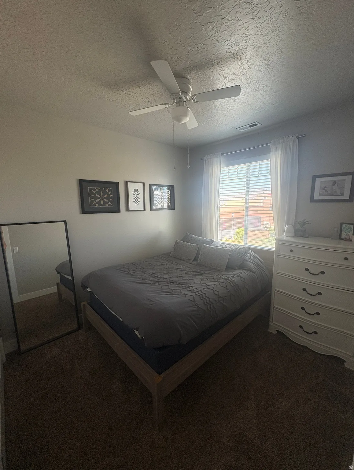 Carpeted room with window and a ceiling fan