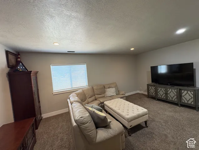 Carpeted room with recessed lighting and a single window featuring horizontal blinds
