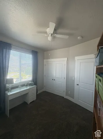 Room featuring a window with blinds, a ceiling fan, and carpeted flooring