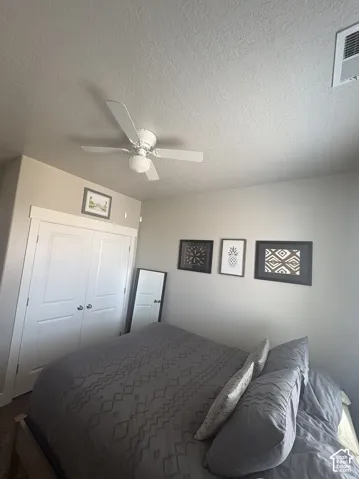 Bedroom featuring a ceiling fan, window-mounted air conditioning unit, and carpeted flooring
