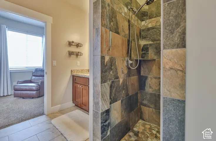 Stone-tiled shower with a pebble-stone floor and built-in niche