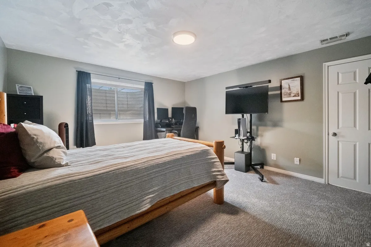 Carpeted room with a textured ceiling, a flush-mount ceiling light, and a white paneled door