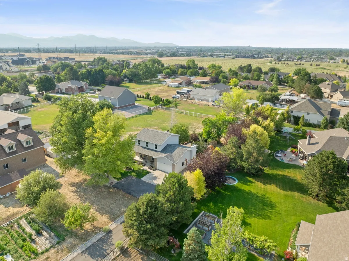 Expansive property featuring a large grassy area, mature trees, and mountainous backdrop