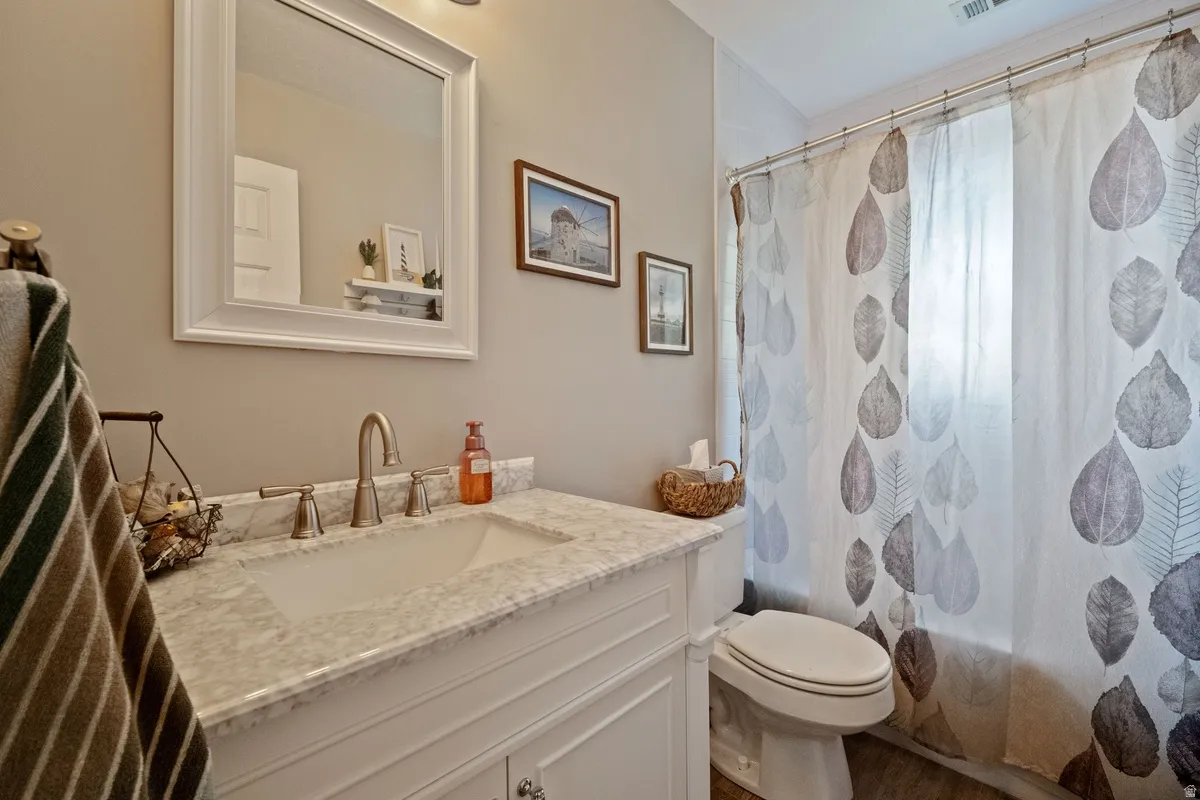 Bathroom vanity with a white framed mirror, brushed nickel faucet, and a light-toned countertop