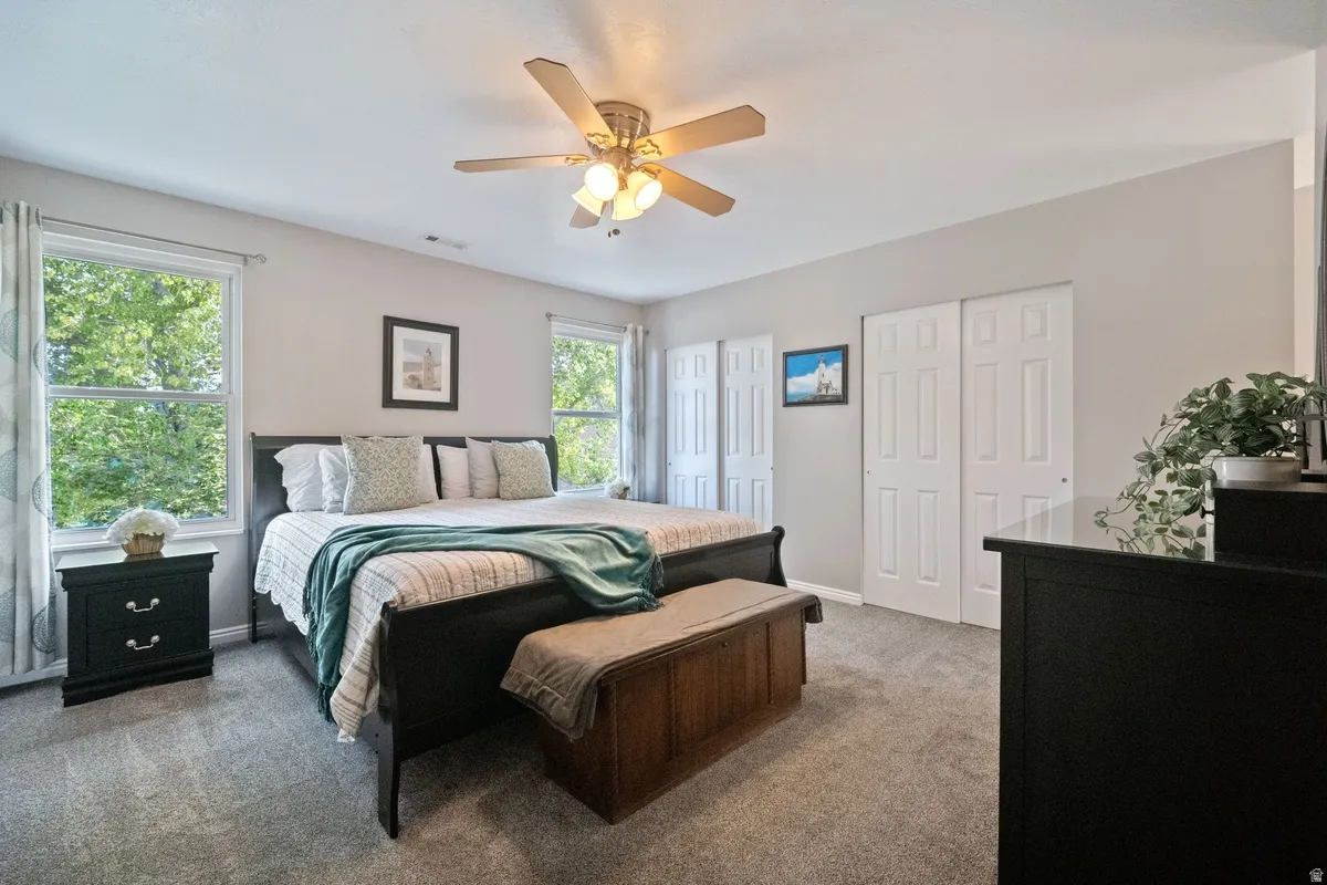 Spacious bedroom featuring light gray wall paint and gray carpet flooring