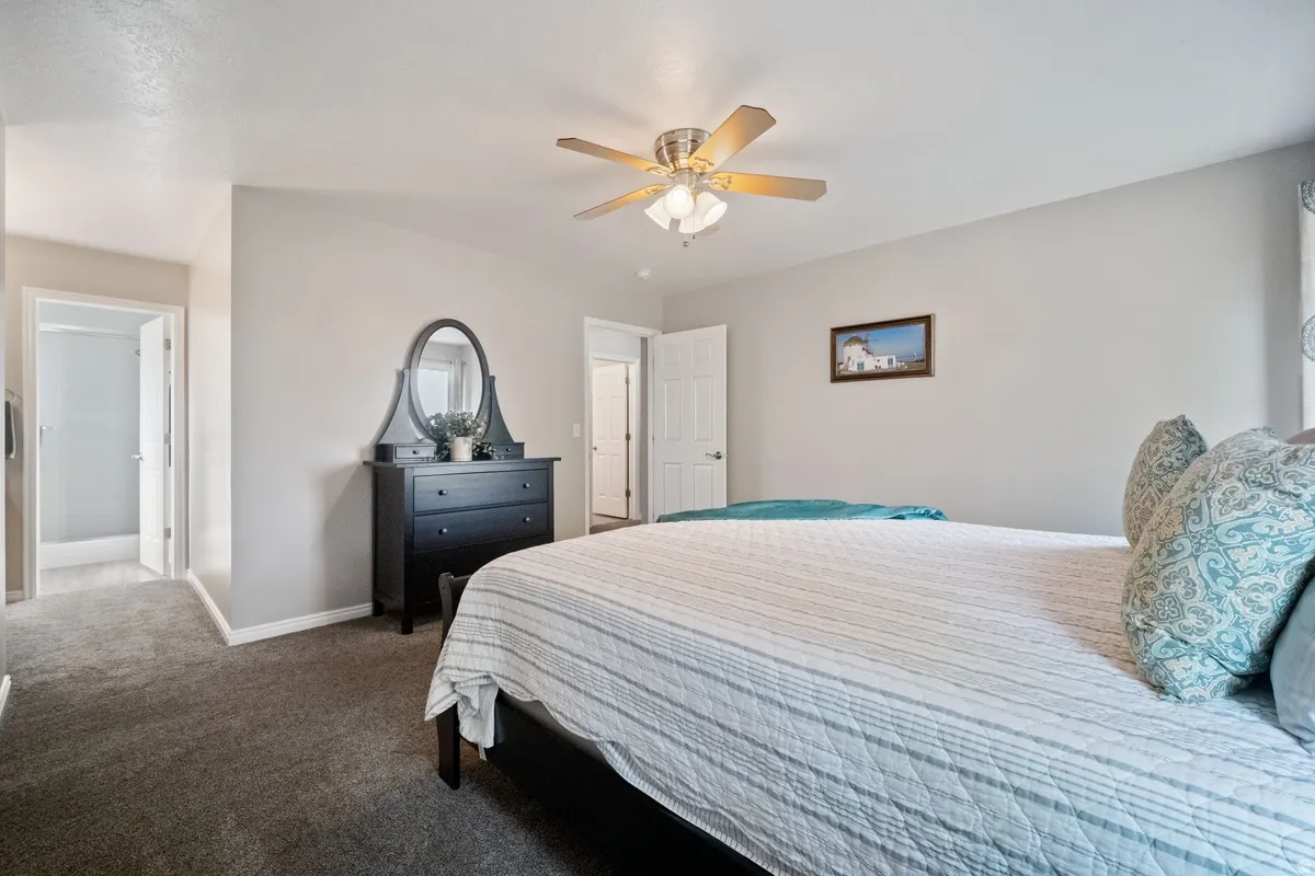 Neutral wall paint throughout, plush carpeting, ceiling fan with integrated lighting, and white trim