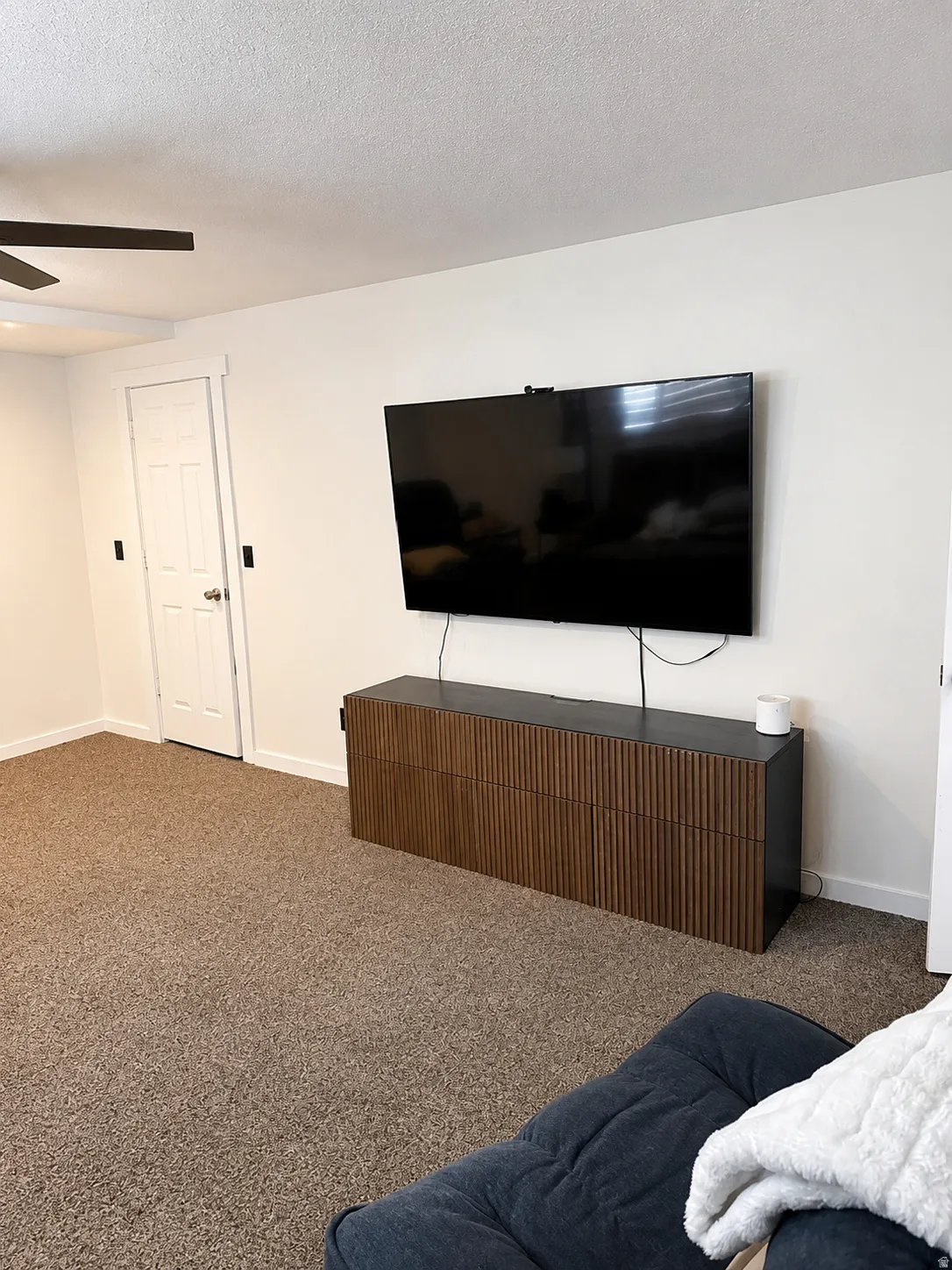 Carpeted flooring, white interior doors, and a ceiling fan