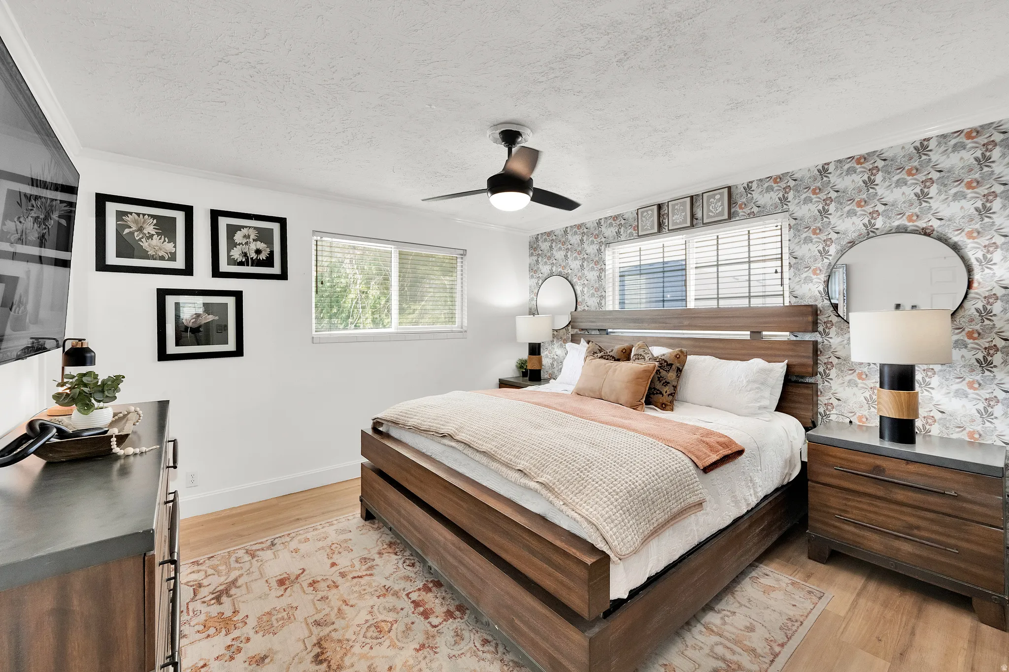 Bedroom featuring wood-finish flooring and a floral accent wall