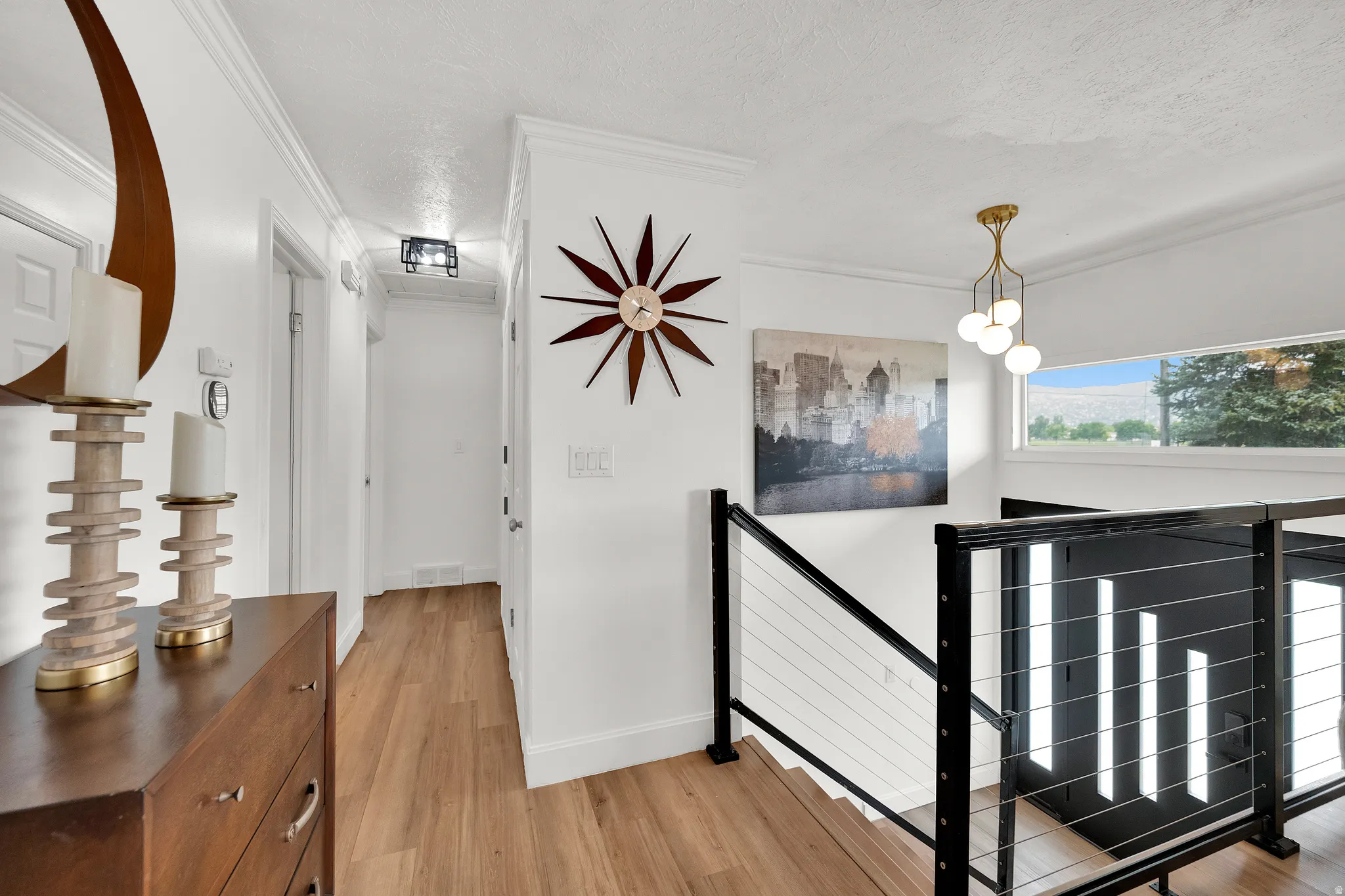 Modern stairwell featuring black metal railings with cable infill