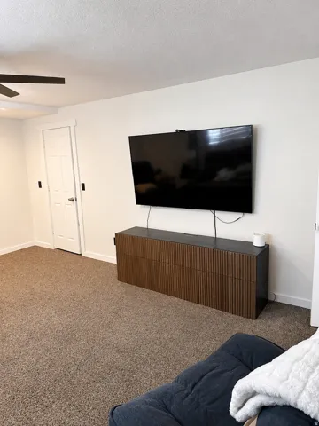 Carpeted flooring, white interior doors, and a ceiling fan