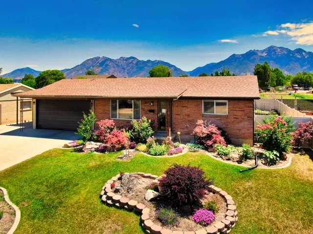 Brick exterior with a brown shingle roof, complemented by a concrete driveway and an attached garage