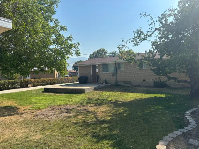Charming mid-century home with a spacious, level lawn surrounded by mature trees