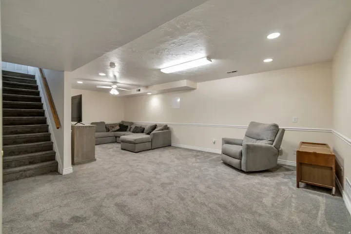Carpeted recreation room featuring white baseboards, chair rail molding, and recessed lighting