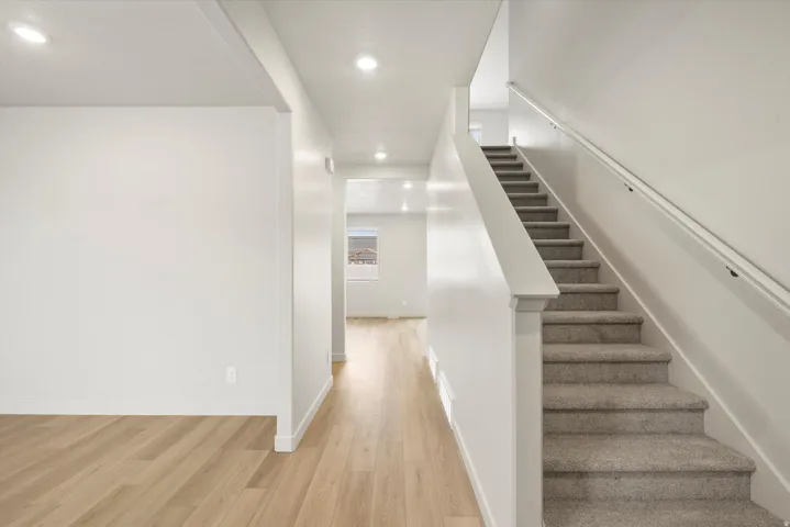 Staircase featuring carpeted treads and a handrail