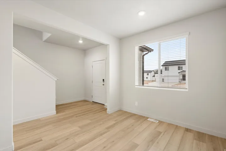 Entryway with light wood-finish flooring, white baseboards, and neutral wall paint