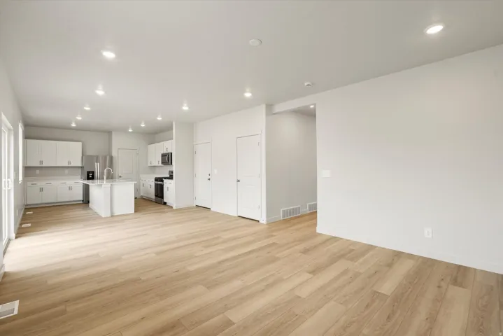 Open-concept living area featuring wood-finish flooring, recessed lighting, and white walls