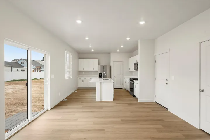 Spacious open-concept living area featuring wood-finish flooring and recessed lighting